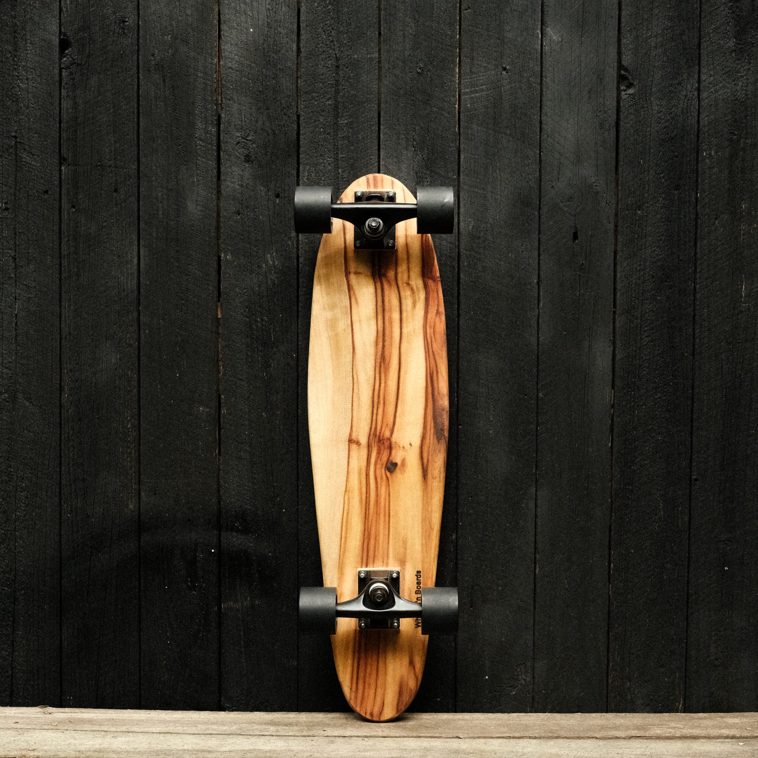 Back of a cruiser skateboard with trucks and wheels in black
