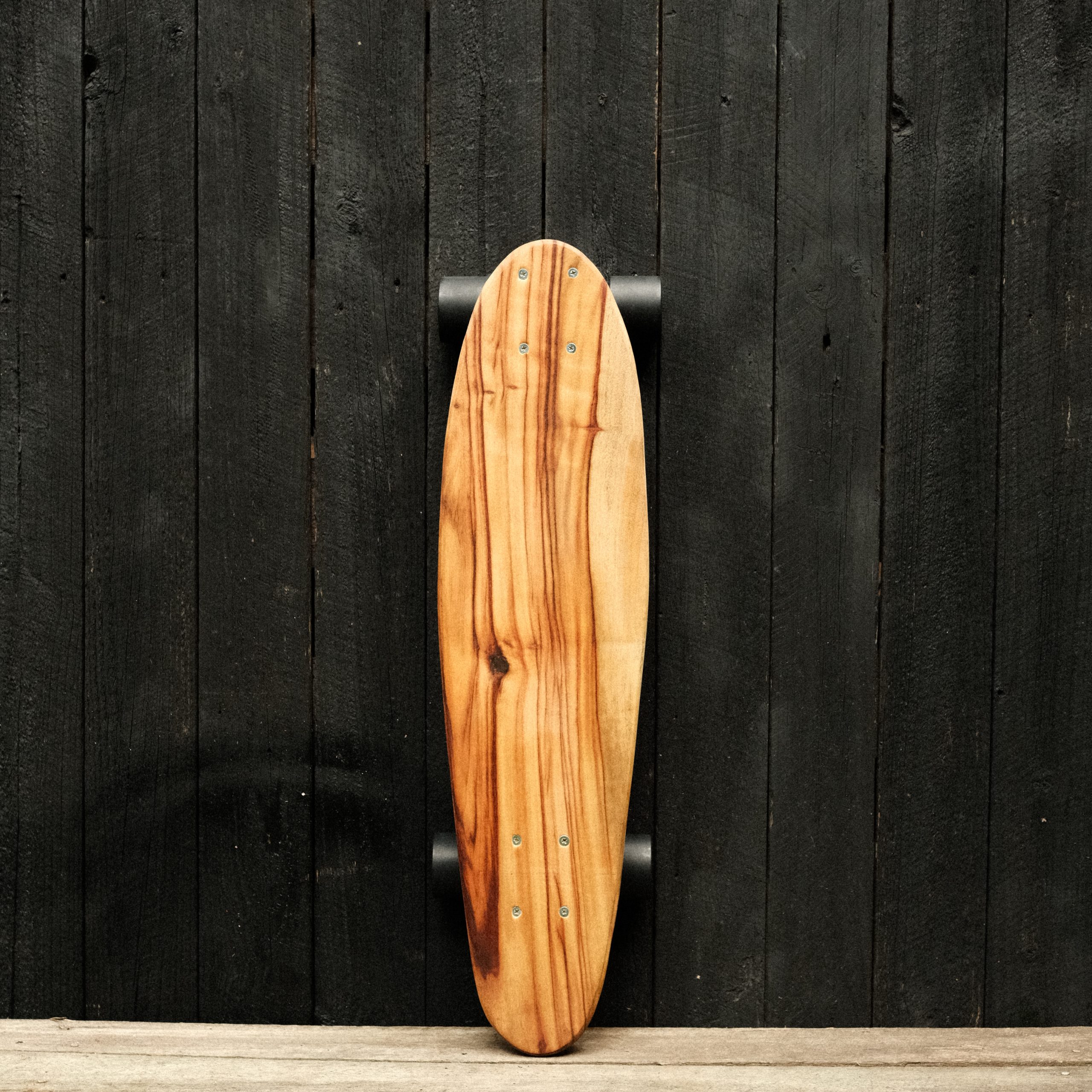 Front of a cruiser skateboard with trucks and wheels in black