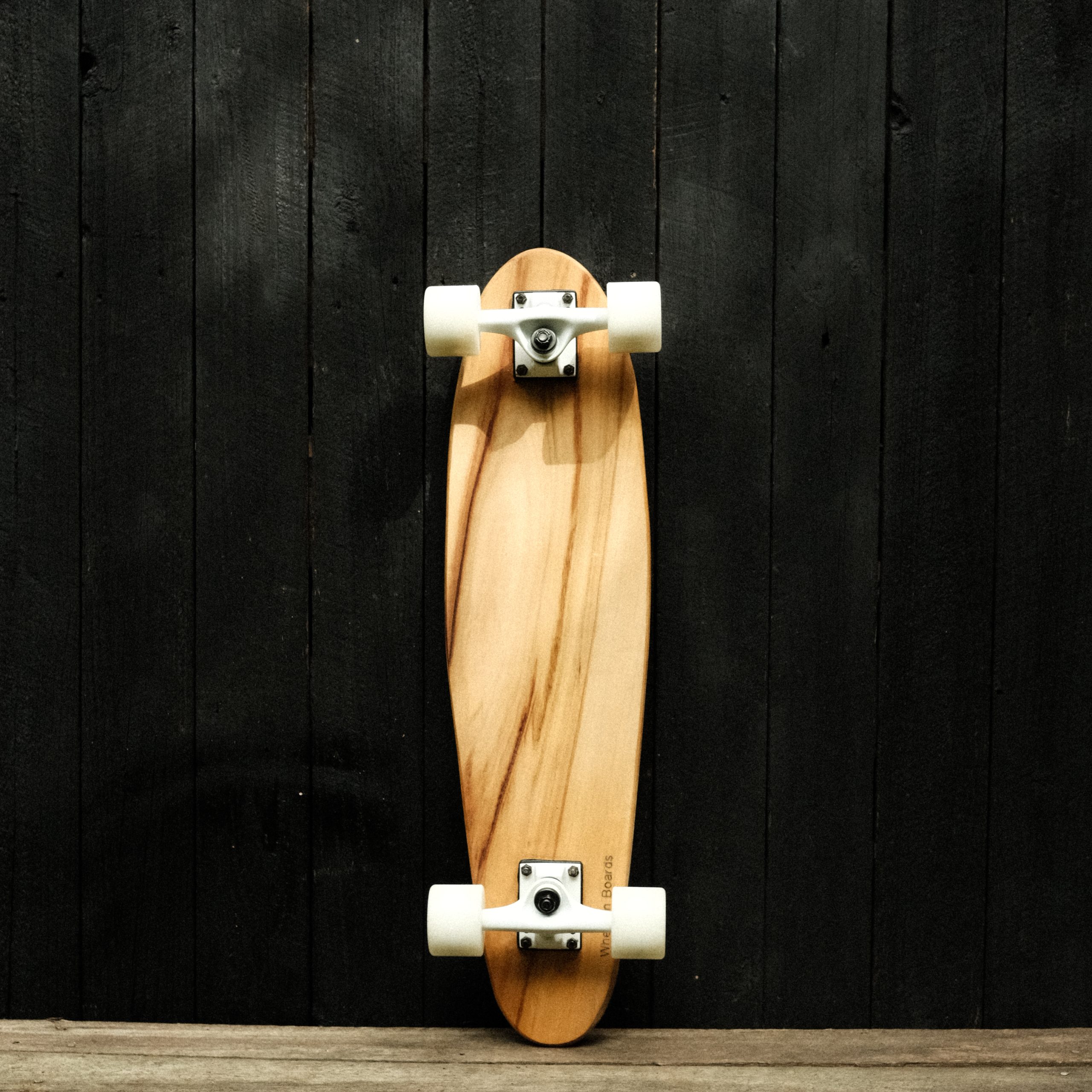Back of a cruiser skateboard with trucks and wheels in white