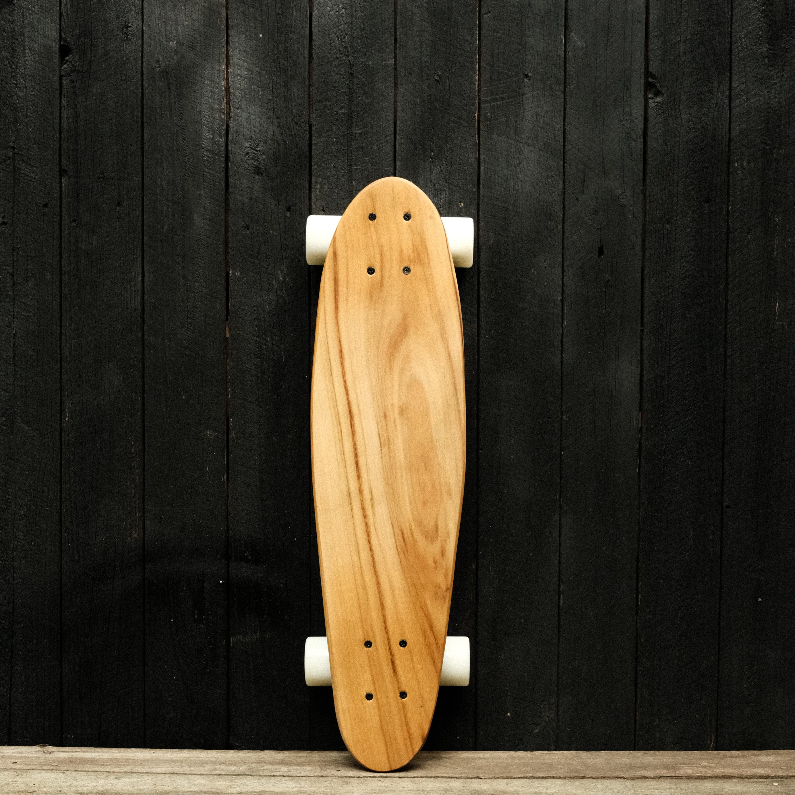 Front of a cruiser skateboard with trucks and wheels in white