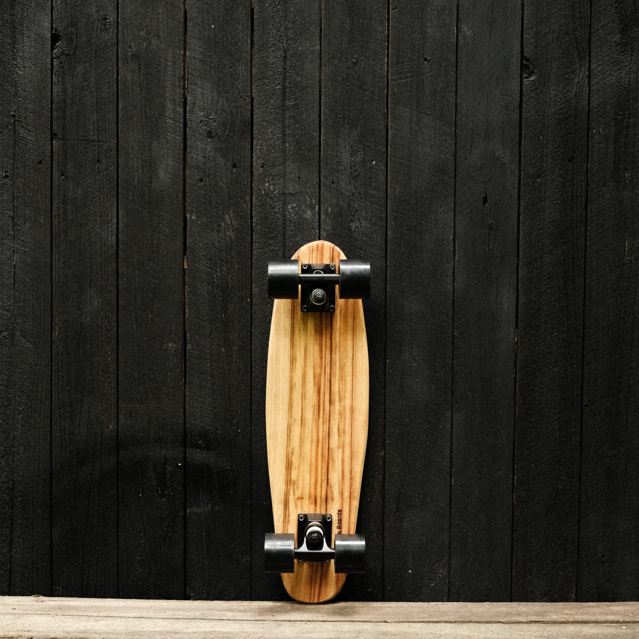 Back of a penny skateboard with trucks and wheels in black