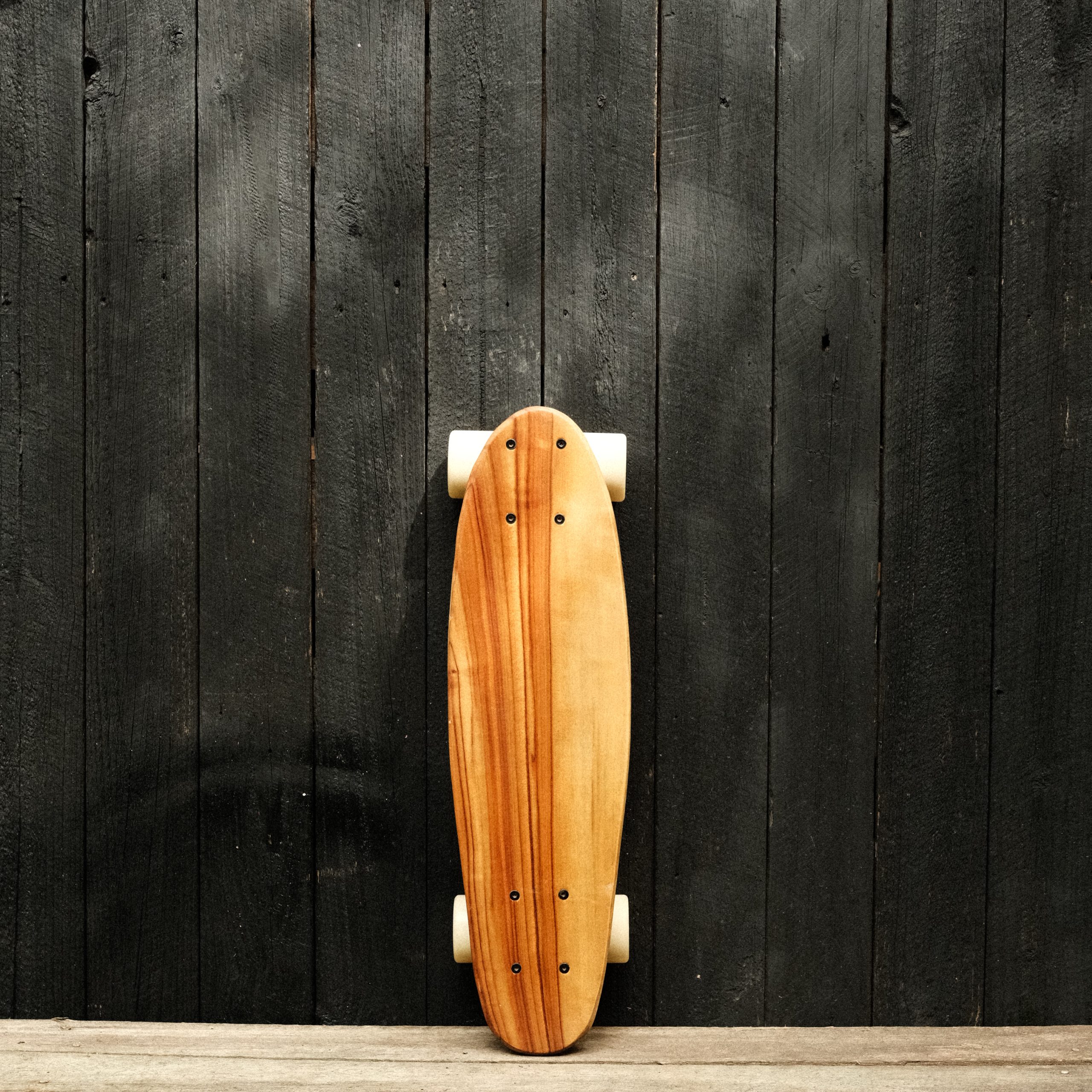 Front of a penny skateboard with trucks and wheels in white