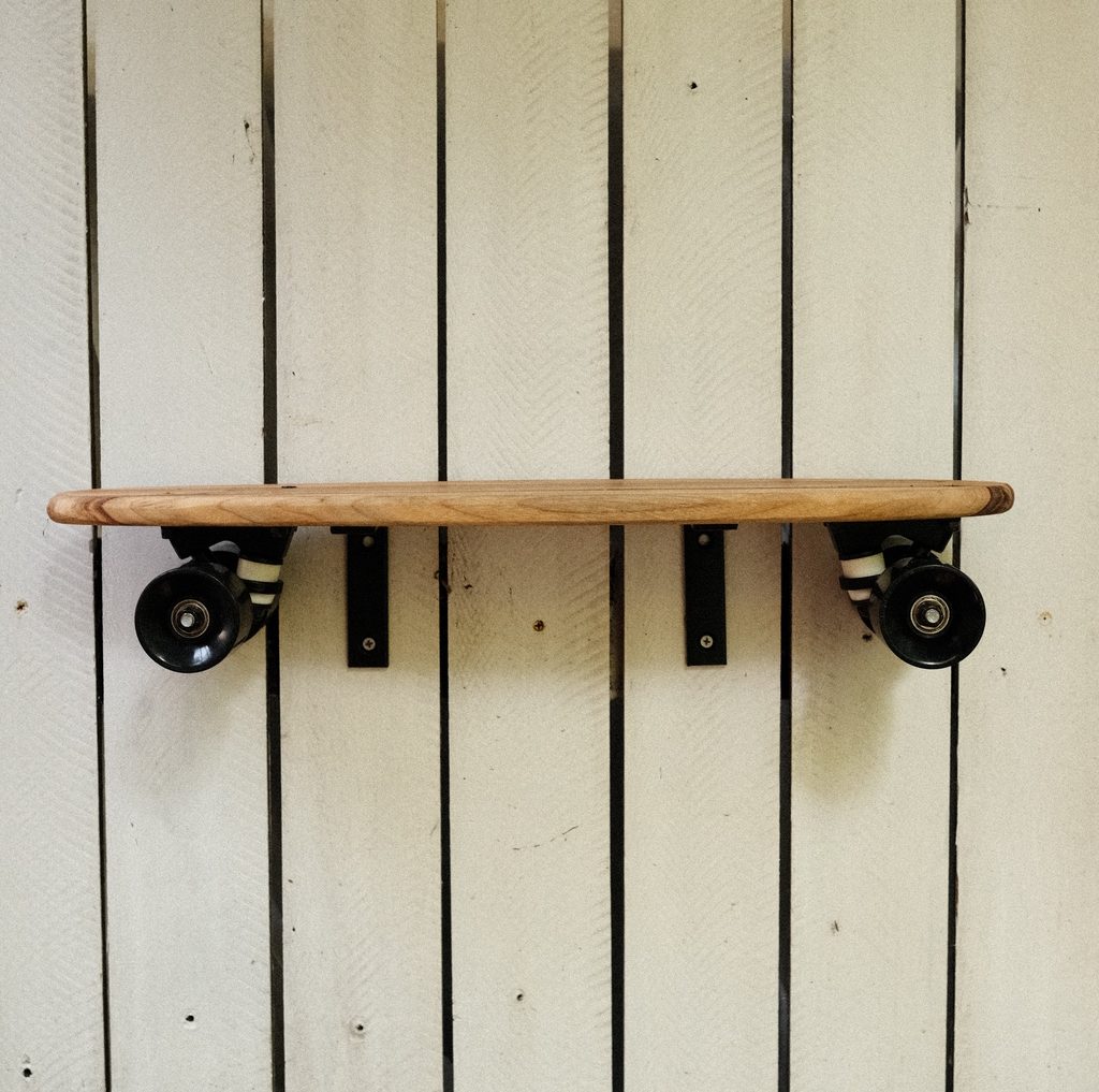 Skateboard shelf with trucks and wheels in black